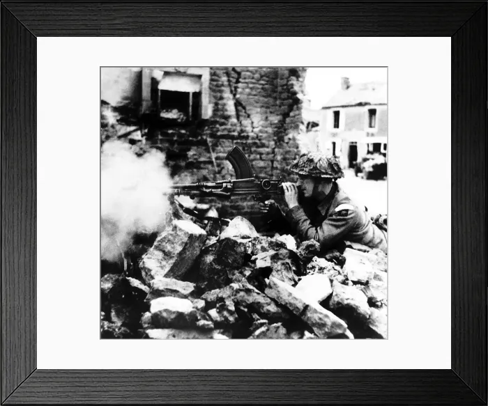 Framed Print : Dorset Regiment soldier fires a machine gun as they battle through a French village Framed Print : Dorset Regiment soldier fires a machine gun as they battle through a French village