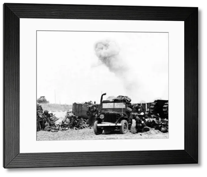 Framed Print : Allied troops take shelter behind their vehicles as German shells pound the French beach