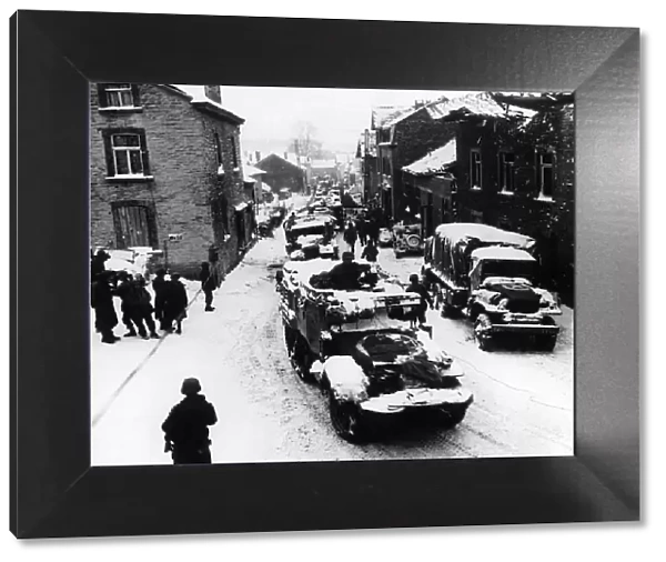 American troops pass through snow-covered street in Lierheux Belgium during WW2