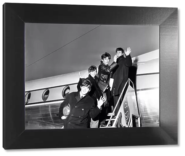 The Beatles wave from the steps of their plane at Yeadon airport after doing a show at