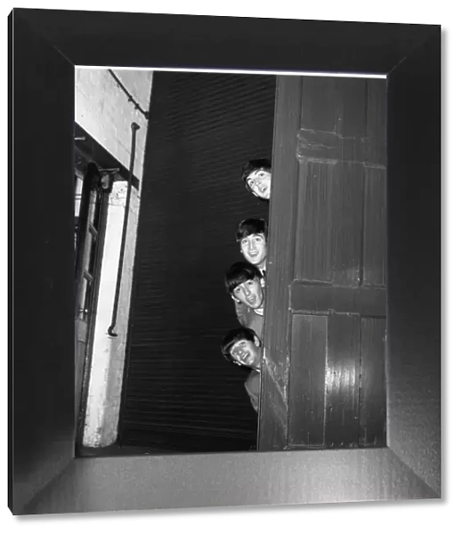 The Beatles peering out from behind a door. before the groups appearence at Sunday Night