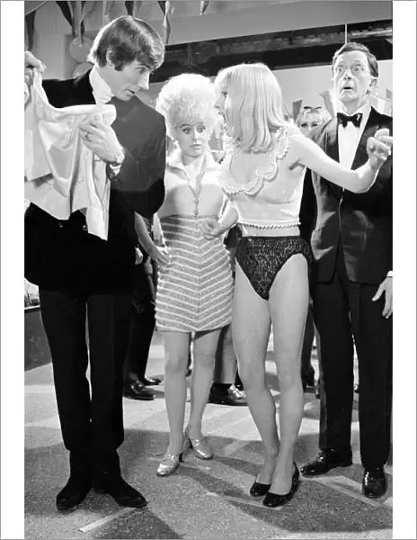 Jim Dale rips the skirt off Elizabeth Knight at a party attended by Barbara Windsor