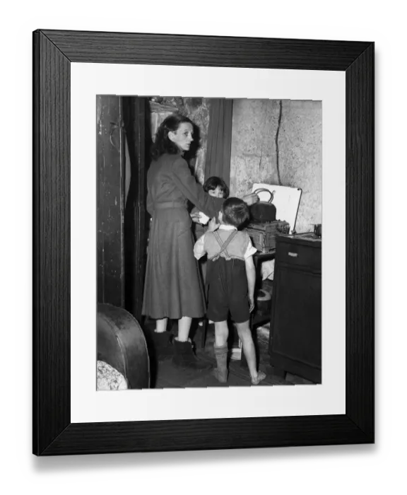 Framed Print : A Birmingham housewife seen here with her family in the kitchen of her condemned terrace Framed Print : A Birmingham housewife seen here with her family in the kitchen of her condemned terrace