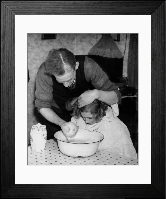 Framed Print : A man washing his daughters hair and face using soapy water in a bowl in their Framed Print : A man washing his daughters hair and face using soapy water in a bowl in their