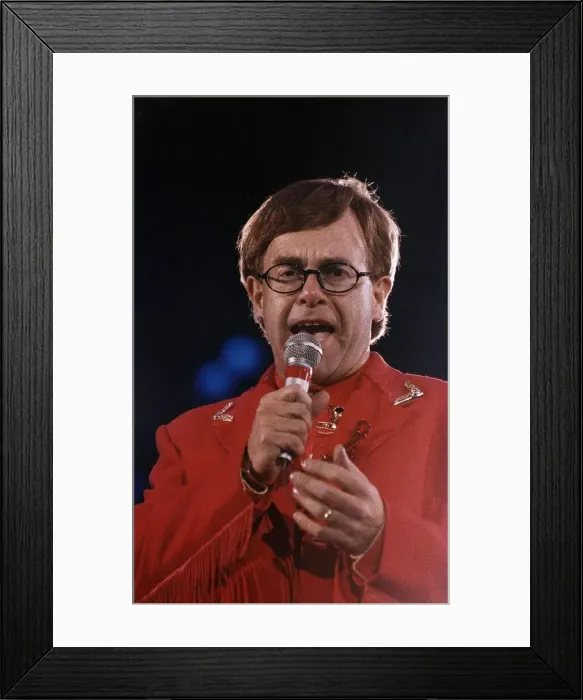 Framed Print : Elton John circa 1992 Wearing Red Suit as he holds microphone during a Freddie Framed Print : Elton John circa 1992 Wearing Red Suit as he holds microphone during a Freddie