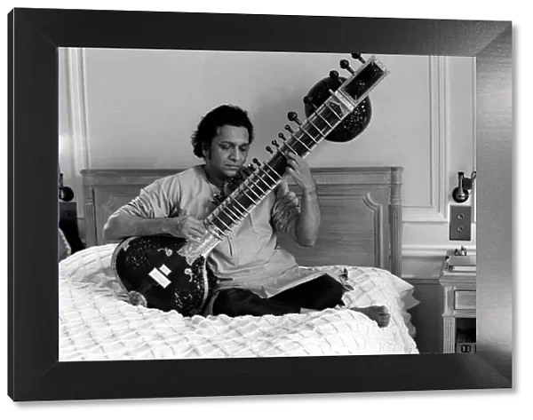 Ravi Shankar playing the sitar in his suite at the Savoy Hotel