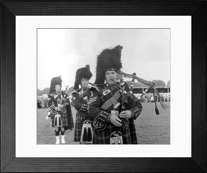 Framed Print : Playing the bagpipes wearing traditional tartan dress at a Highland gathering in Scotland Framed Print : Playing the bagpipes wearing traditional tartan dress at a Highland gathering in Scotland