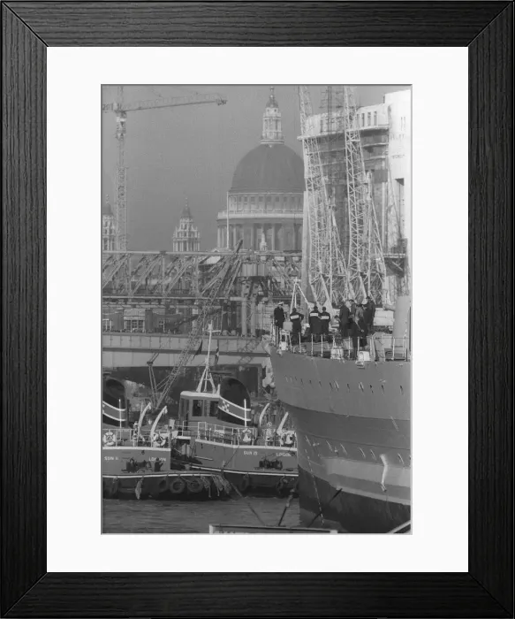 Framed Print : HMS Belfast sailing up the Thames passing St Pauls Cathedral to her mooring in the Pool