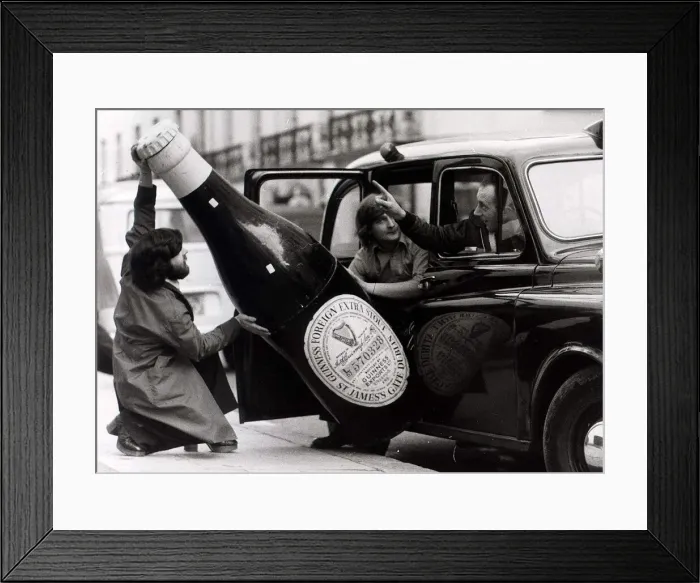 Framed Print : Ron Nicholson (left) Bill Barnard trying to get a large bottle of Guinness into a London Framed Print : Ron Nicholson (left) Bill Barnard trying to get a large bottle of Guinness into a London