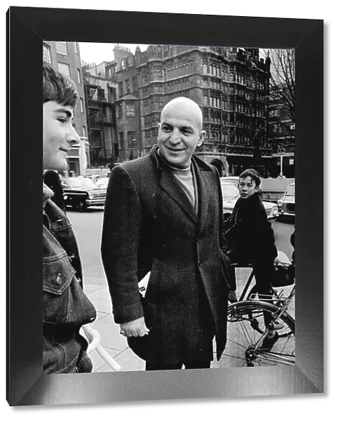 Actor Savalas Telly surronded by young fans on bikes, during a walk in London with his