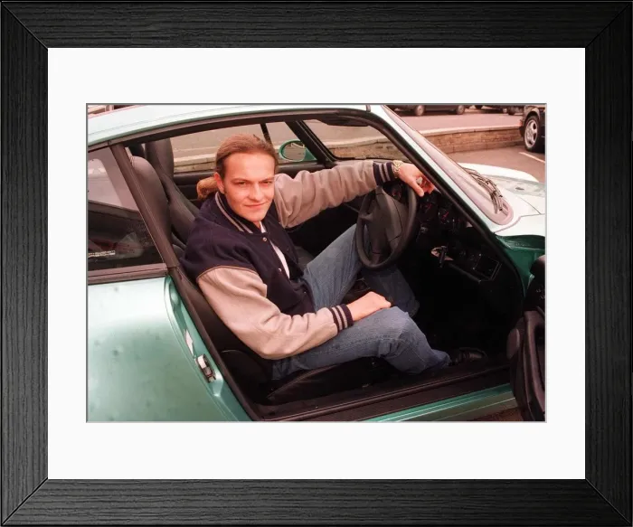 Framed Print : Actor Simon Weir poses sitting in the driving seat of the Porsche Targa 911 car May 1997