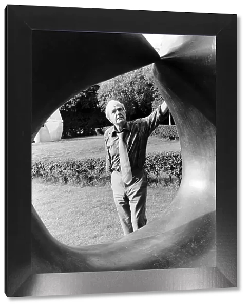 Henry Moore Artist Sculptor looks through one of his sculptures. 1978