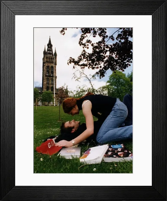 Framed Print : Students lay on the grass on campus kissing Framed Print : Students lay on the grass on campus kissing