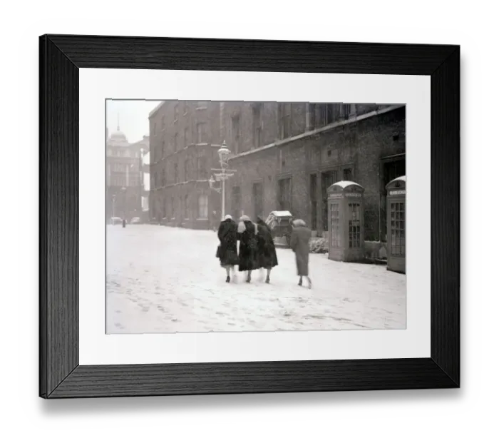 Framed Print : A group of women make their way up the street through the heavy snow past a row of