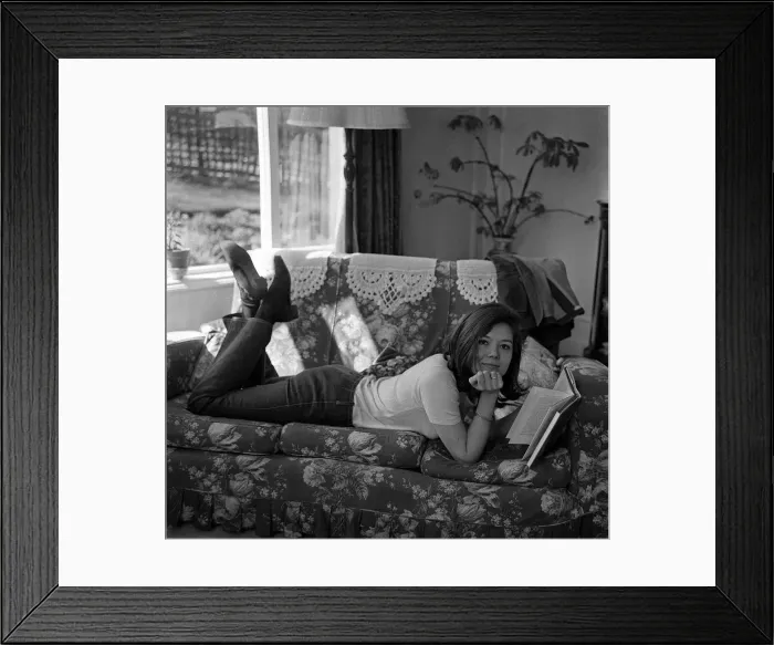 Framed Print : Diana Rigg actress Apr 1965 lying on a sofa at home reading a book Framed Print : Diana Rigg actress Apr 1965 lying on a sofa at home reading a book