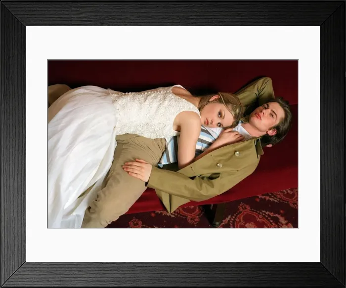 Framed Print : Female model lying on top of a male model along red cinema seats Framed Print : Female model lying on top of a male model along red cinema seats