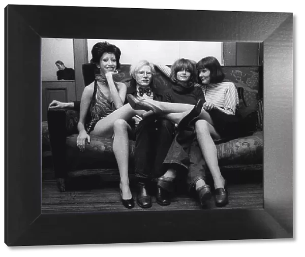 Andy Warhol American pop artist and film producer 1973 sitting on couch with cast