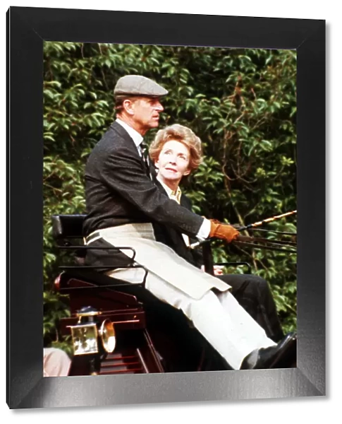 Prince Philip, the Duke of Edinburgh and Nancy Reagan sitting in a carriage driving in