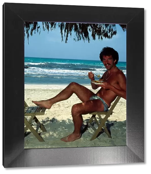 Graeme Souness sitting at the beach in Majorca eating food, 1978