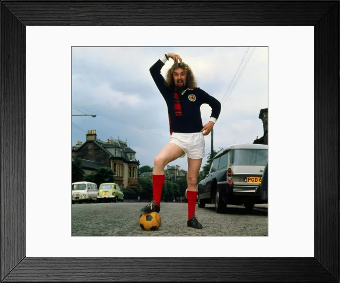 Framed Print : Billy Connolly wearing Scotland football top 1974 A©mirrorpix