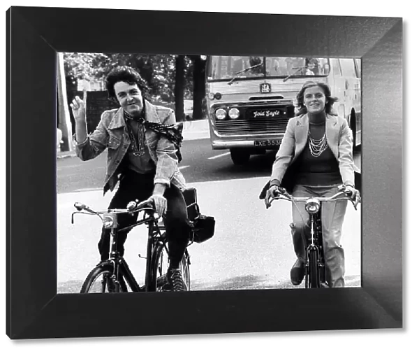 Paul McCartney former singer with The Beatles with wife Linda out riding bicycles