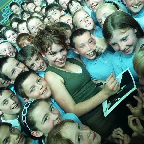 Pop singer Billie Piper signs autographs for a crowd of children June 1998