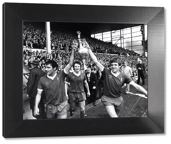 Liverpool players Ray Kennedy (L) and Emlyn Hughes celebrate with the League Championship
