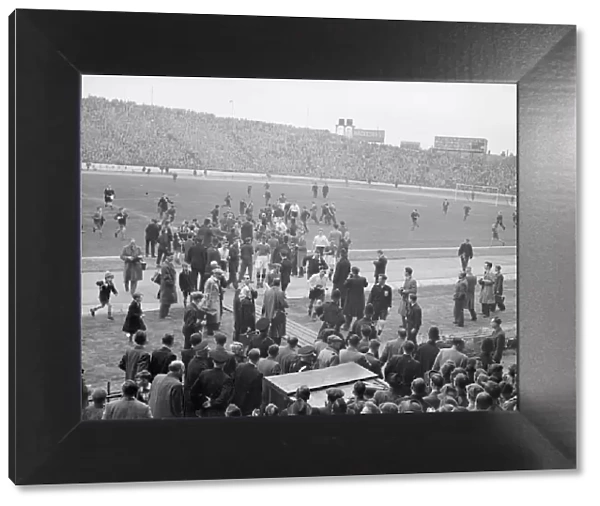 Football 1954  /  55 Season. Large crowds and photographers gather on the pitch at Stamford