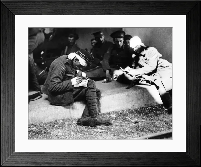 Framed Print : World War One - A wounded British soldier sitting on steps with comrades writes home