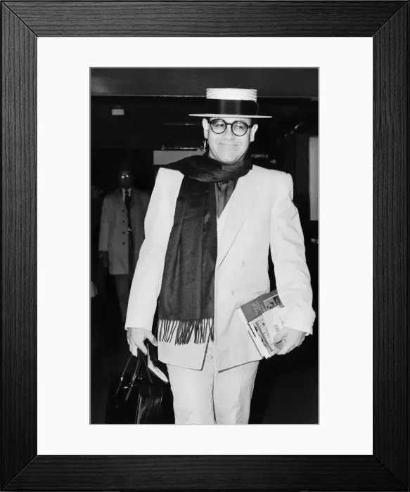 Framed Print : Elton John pop star strolls through the airport on his way to a Californian holiday Framed Print : Elton John pop star strolls through the airport on his way to a Californian holiday
