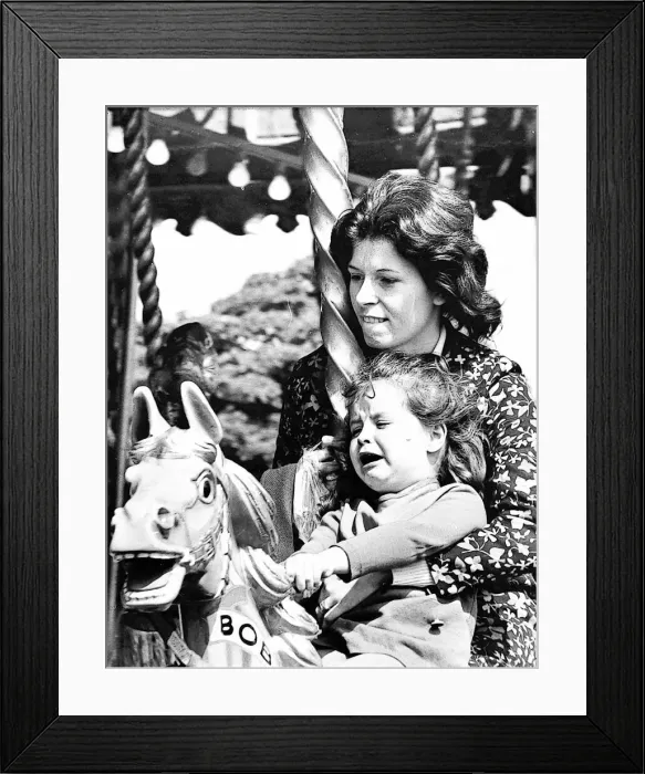 Framed Print : A mum grips on tight to her little girl who is having trouble coming to terms with