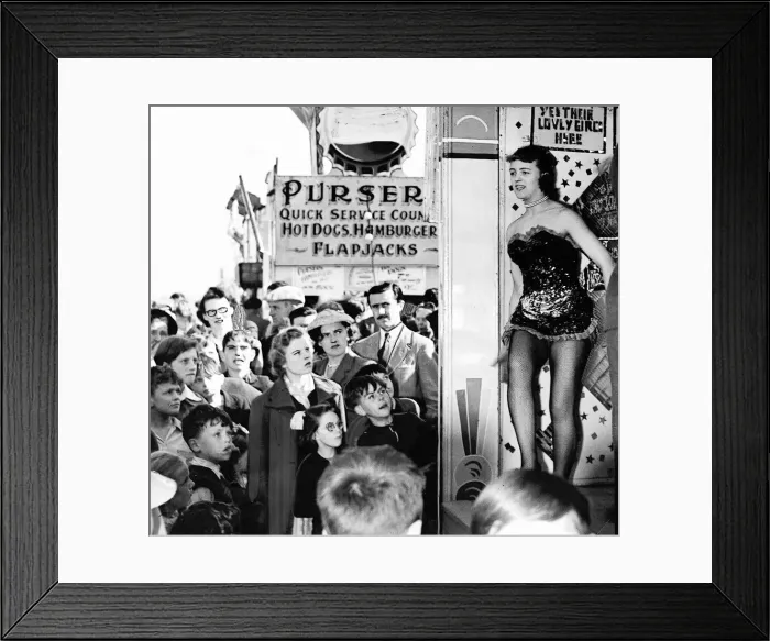 Framed Print : A belle of the sideshows attracts the attention of both young and old