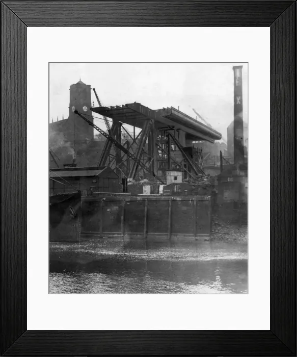 Framed Print : Construction of the Tyne Bridge. A view from the river showing progress being made with Framed Print : Construction of the Tyne Bridge. A view from the river showing progress being made with