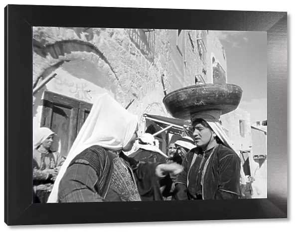 A woman in the market at Bethlehem with a bowl balanced on her head Circa 1935