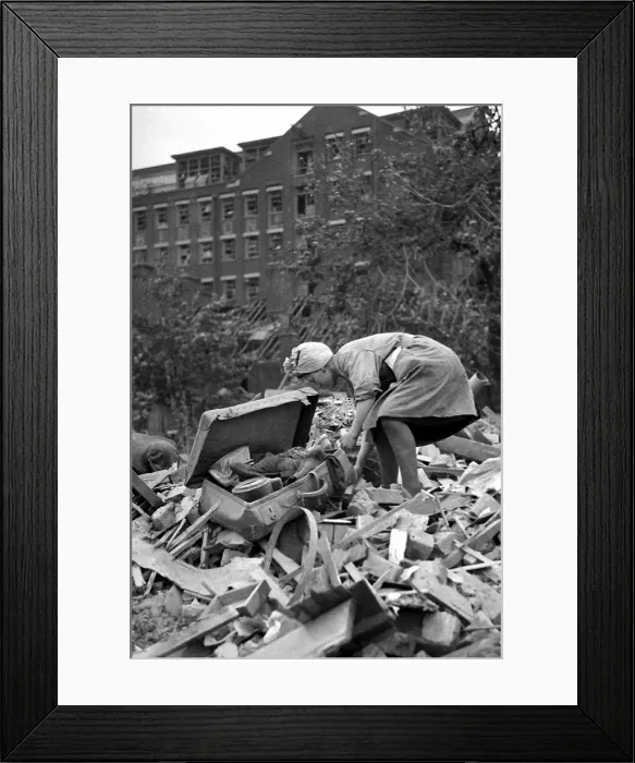 Framed Print : A woman rummages through the debris of bomb damage at New Cross after air raids on London