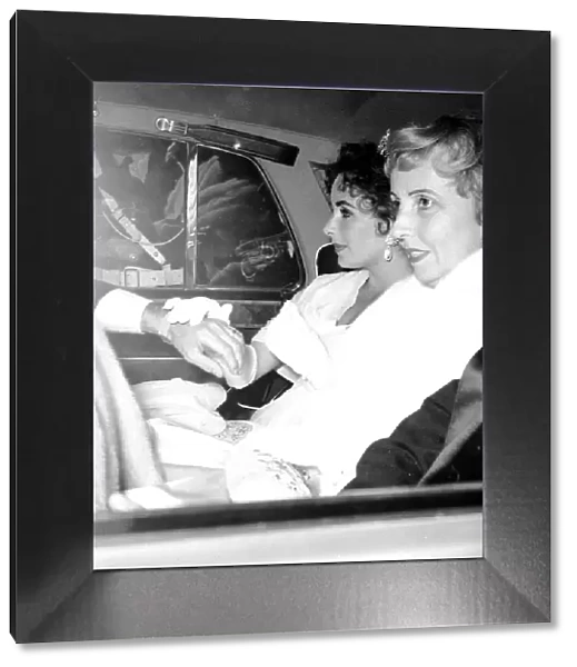 Film actress Elizabeth Taylor seated in the back of a car as she arrives for the opening