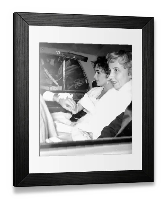 Framed Print : Film actress Elizabeth Taylor seated in the back of a car as she arrives for the opening