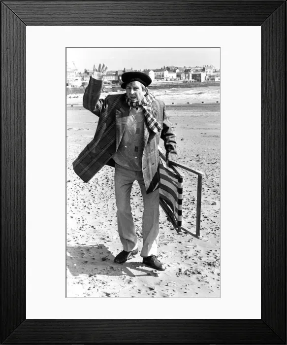 Framed Print : Television comedian Norman Colliercarrying a deckchair on the beach April 1991 Framed Print : Television comedian Norman Colliercarrying a deckchair on the beach April 1991