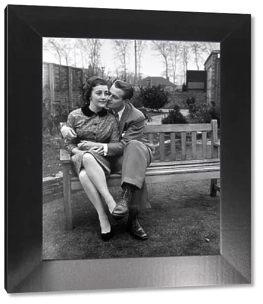 Couple Catherine Egan and Francis Byrne cuddling on a wooden bench in Liverpool