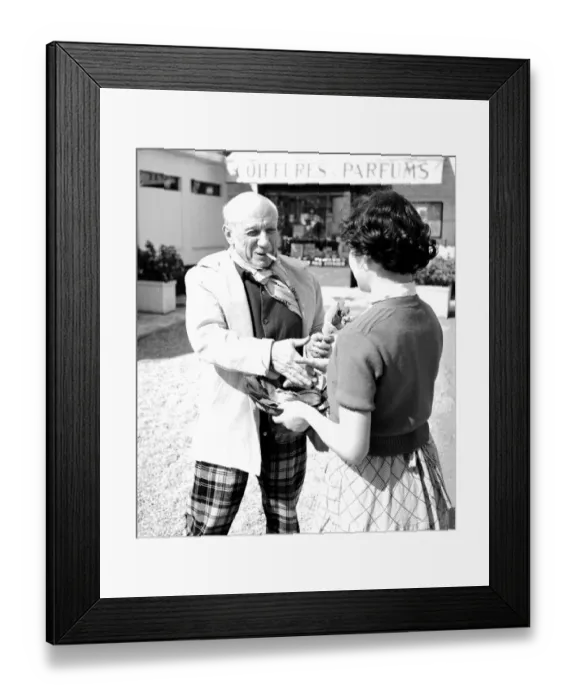 Framed Print : Spanish artist Pablo Picasso shaking hands with a young woman at the Cannes Film