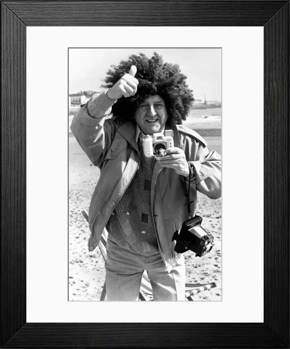 Framed Print : Television comedian Norman Collier wearing a funny wig on the beach April 1991 Framed Print : Television comedian Norman Collier wearing a funny wig on the beach April 1991