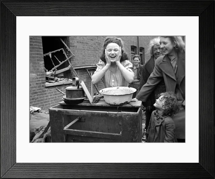 Framed Print : A woman washes her faces surrounded by bomb damage on St Framed Print : A woman washes her faces surrounded by bomb damage on St