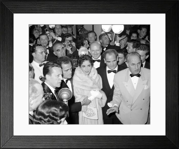 Framed Print : Elizabeth Taylor and husband Mike Todd surrounded by photographers in the theatre before