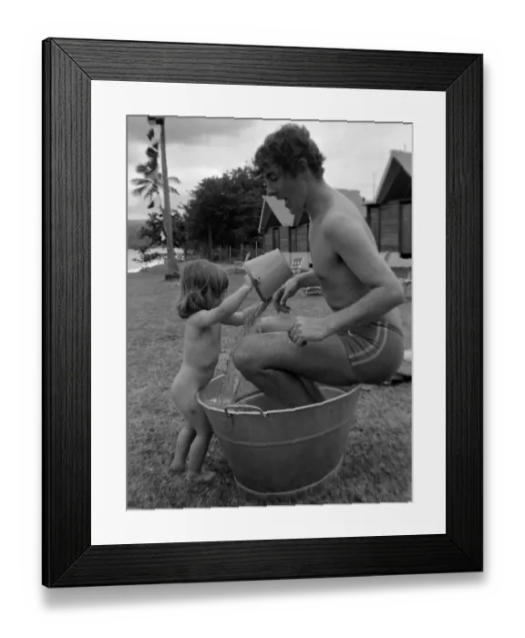 Framed Print : Comedian, actor and publisher Peter Cook with daughter Lucy during a holiday in Grenada Framed Print : Comedian, actor and publisher Peter Cook with daughter Lucy during a holiday in Grenada