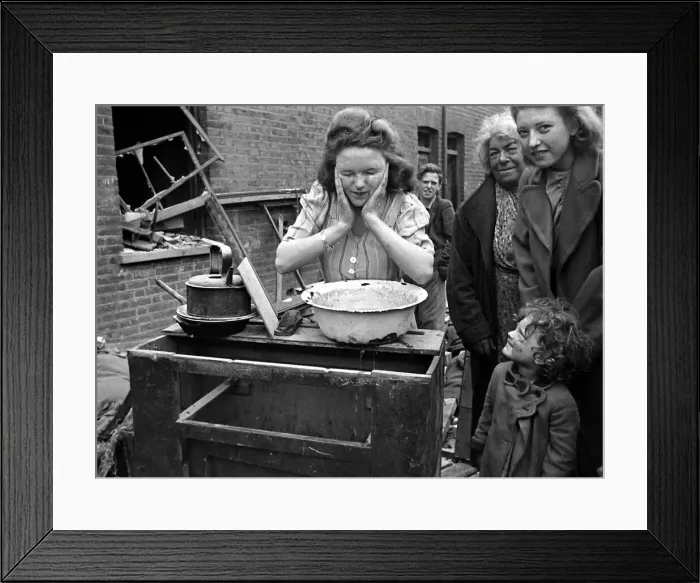 Framed Print : A woman washes her faces surrounded by bomb damage on St Framed Print : A woman washes her faces surrounded by bomb damage on St