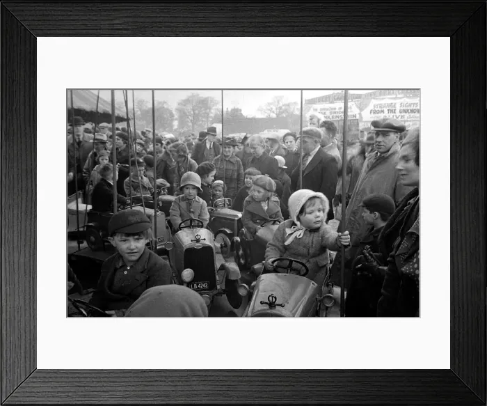 Framed Print : Parents watch as their children ride on a merry-go-round at Blackheath Fair April