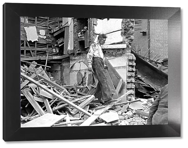 A man wades through the debris of bomb damage in Kings Cross after air raids