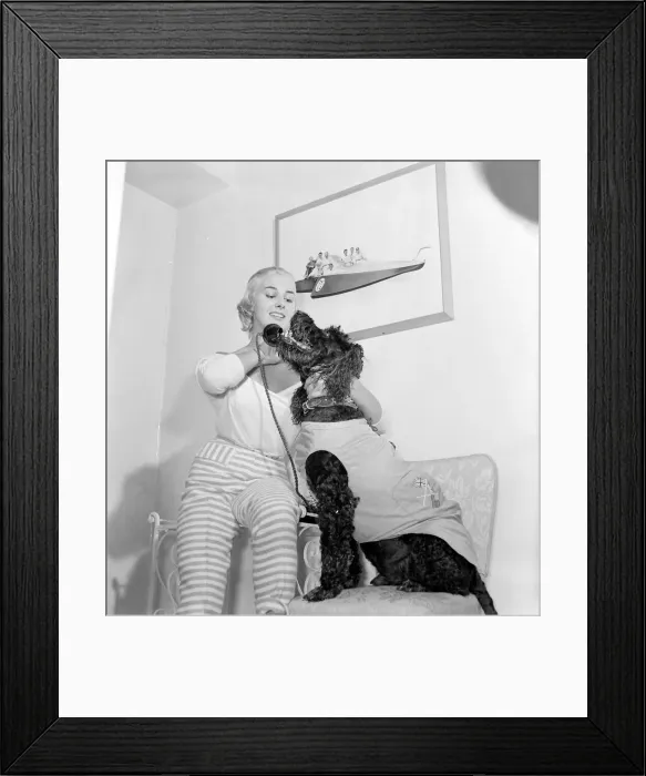 Framed Print : Dory Swan and her pet dog talking on the telephone Circa 1955 Framed Print : Dory Swan and her pet dog talking on the telephone Circa 1955