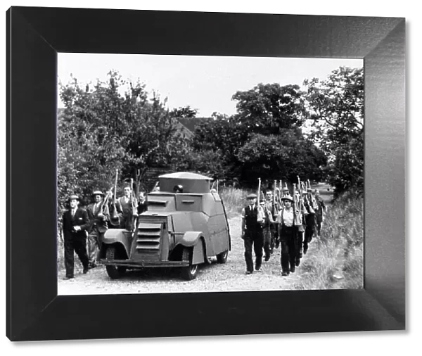 Workers at a Jam Factory march besides their own armoured car during a lunch break