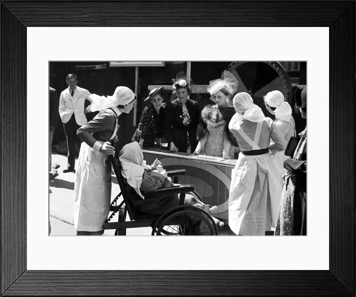 Framed Print : Nurses pushing a child in a wheelchair around Barts Fair, circa 1938 Framed Print : Nurses pushing a child in a wheelchair around Barts Fair, circa 1938